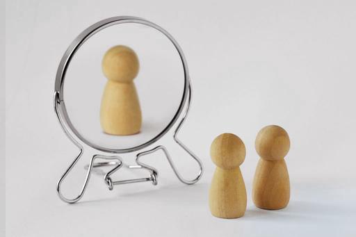 narcissist metaphor, two wooden peg people looking into mirror and only seeing one back