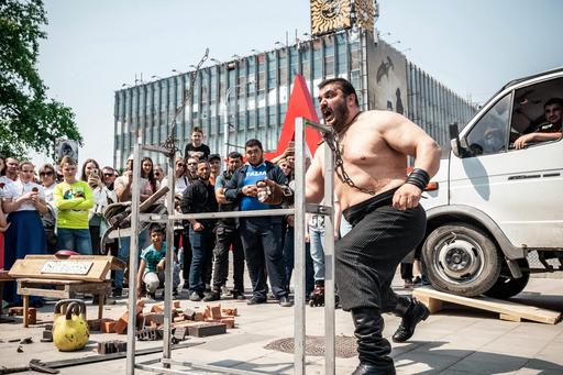 man in strong man competition in crowd