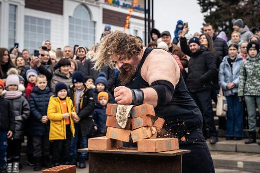 strongman competition, man hitting brick in a crowd